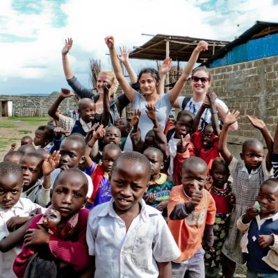Projects Abroad teenage volunteers working with children in Ghana, take a group photo. While doing community volunteer work in Ghana, teenagers take a group photo with children.
